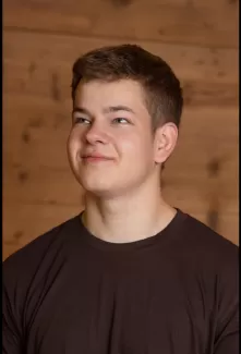 Pascal Kühni in einem Zimmerei Hirschi T-Shirt schaut nach oben links