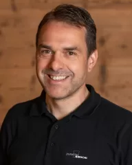 Wüthrich Gottfried mit einem schwarzen Polo Shirt mit Zimmerei Hirschi Logo