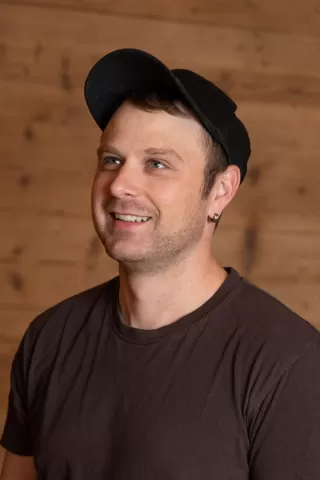 Martin Gerber mit schwarzem Hut Cap und einem braunen Zimmerei Hirschi T-Shirt