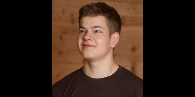 Pascal Kühni in einem Zimmerei Hirschi T-Shirt schaut nach oben links