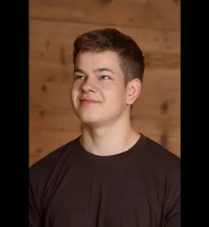 Pascal Kühni in einem Zimmerei Hirschi T-Shirt schaut nach oben links