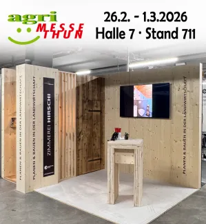 Flyer der Zimmerei Hirschi AG zur Teilnahme an der Agri Messe Thun vom 26. Februar bis 1. März 2026 in Halle 7, Stand 711. Abgebildet ist ein Holz-Messestand mit massiven Holzelementen, einer rustikalen Tür und einem Bildschirm. Der Slogan ‚Planen & Bauen in der Landwirtschaft‘ ist mehrfach sichtbar. Unten steht: ‚Wir freuen uns auf euren Besuch!
